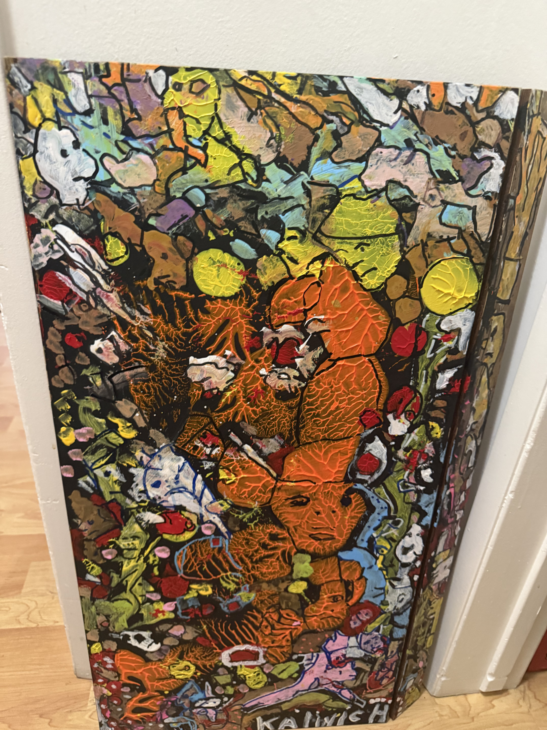 Colourful painting by Stephen John Kalinich filled with faces and patterns in orange, yellow and green